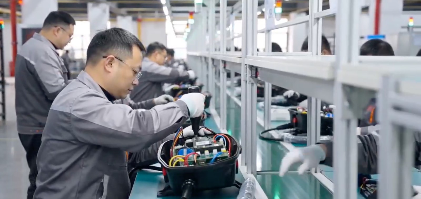 Charger assembly line at eectec's factory, technicians assembling units